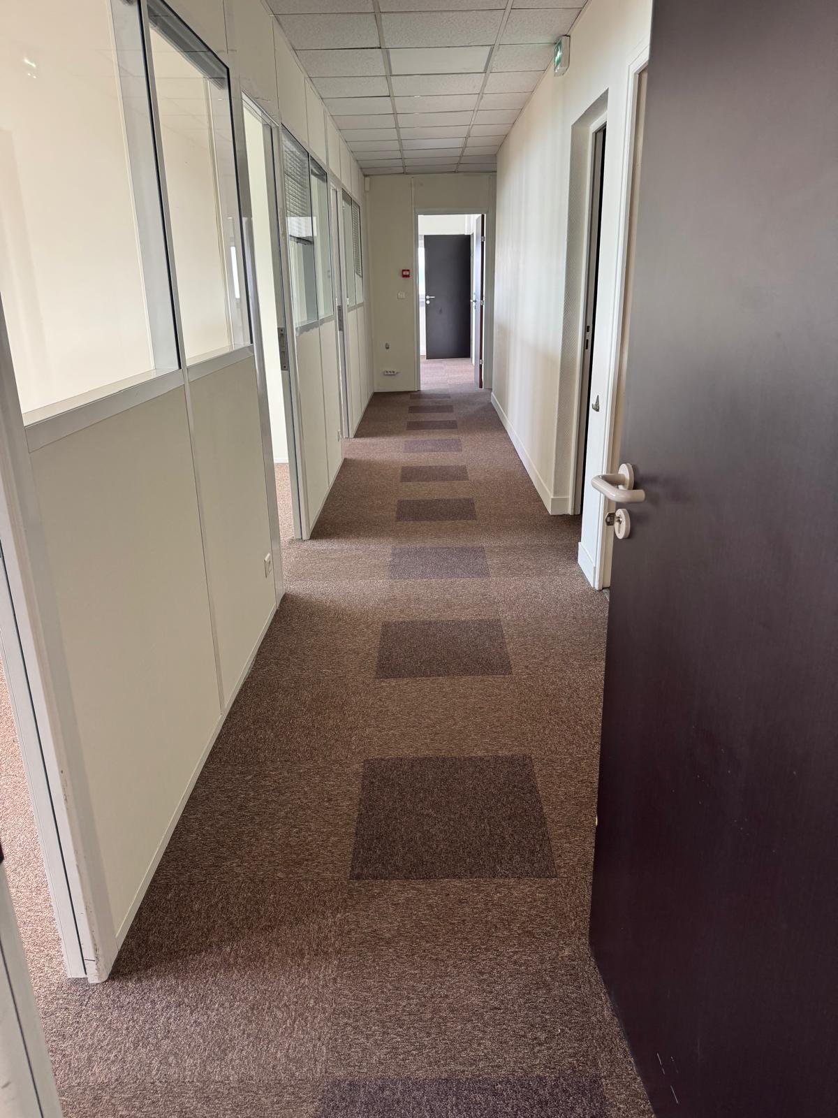 Couloir de desserte des bureaux avec cloisons vitrées